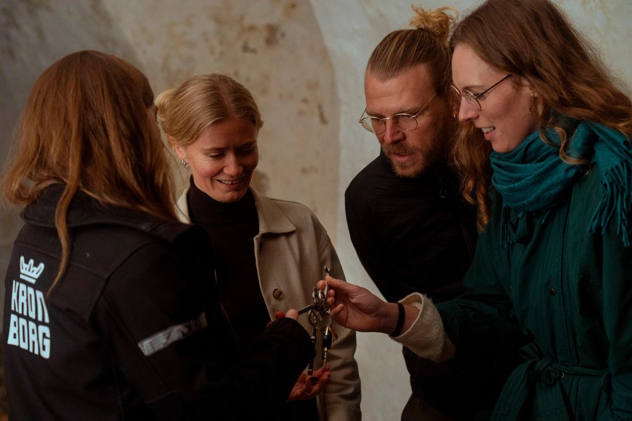 Fire personer ser på historiske nøgler sammen.